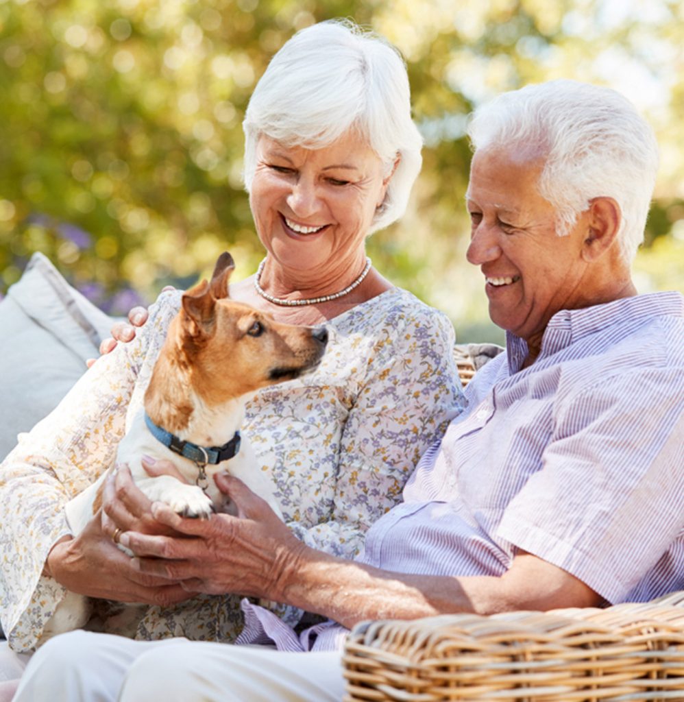 Older man and woman with dog talking about nursing home planning